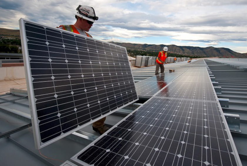 construction workers installing solar panels